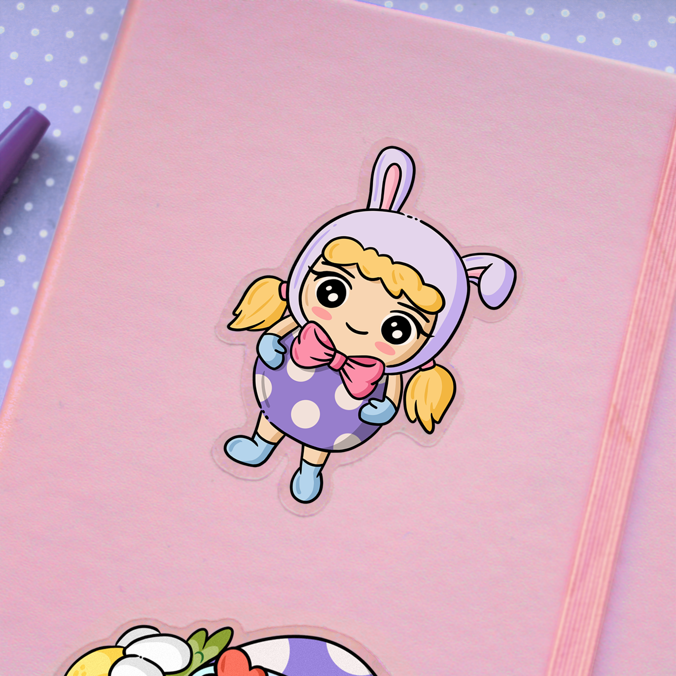 Hand drawn vinyl sticker of a kawaii girl with blonde hair wearing a bunny hat and an easter egg costume on a planner