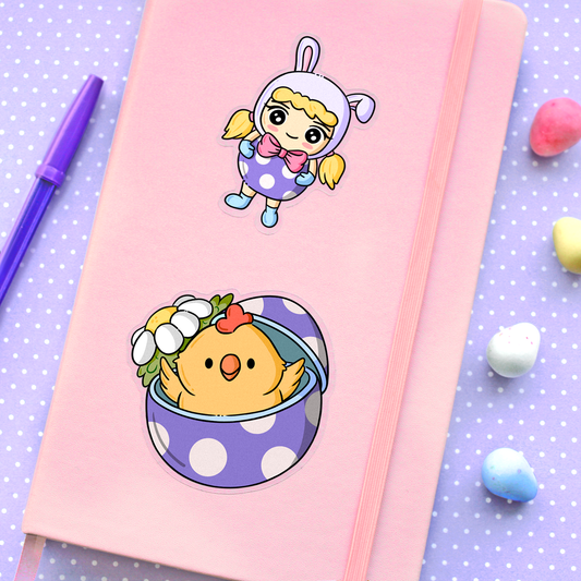 Hand drawn vinyl stickers of a kawaii girl wearing bunny hat and easter egg costume and a chicken in an easter egg with a daisy on a planner