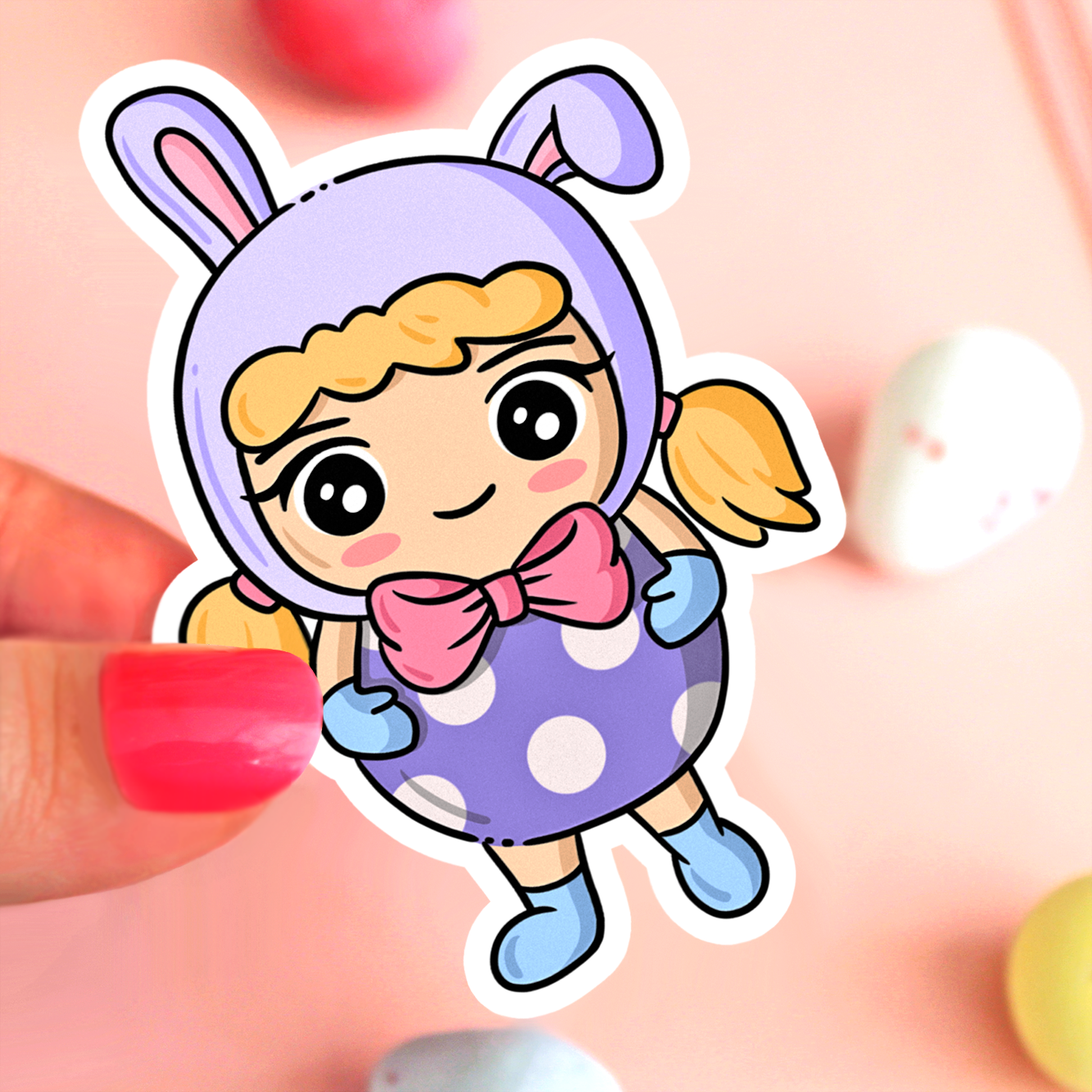 Hand drawn vinyl sticker of a kawaii girl with blonde hair wearing a bunny hat and an easter egg costume