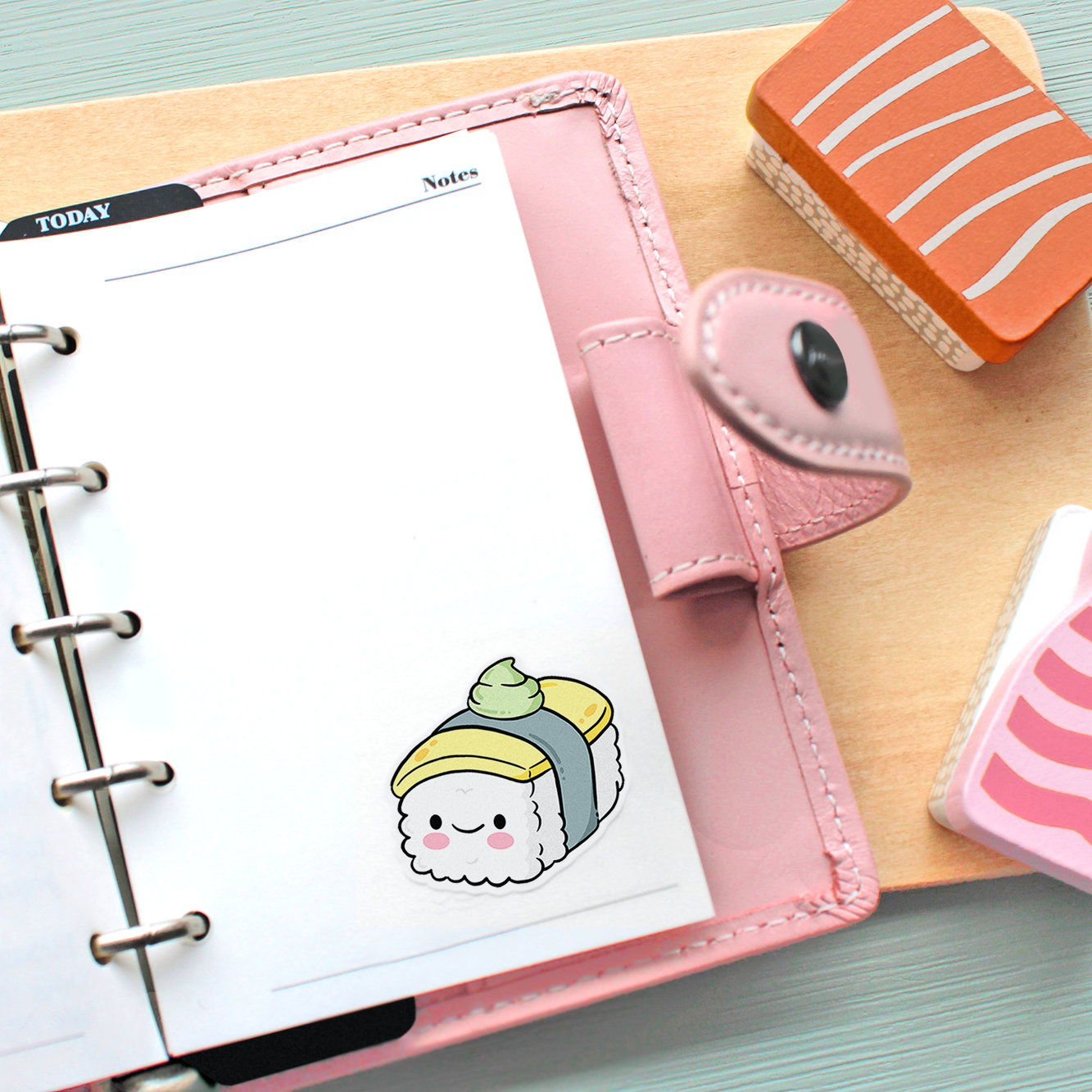 Hand drawn sticker of a kawaii egg nigiri on a page in a pink planner